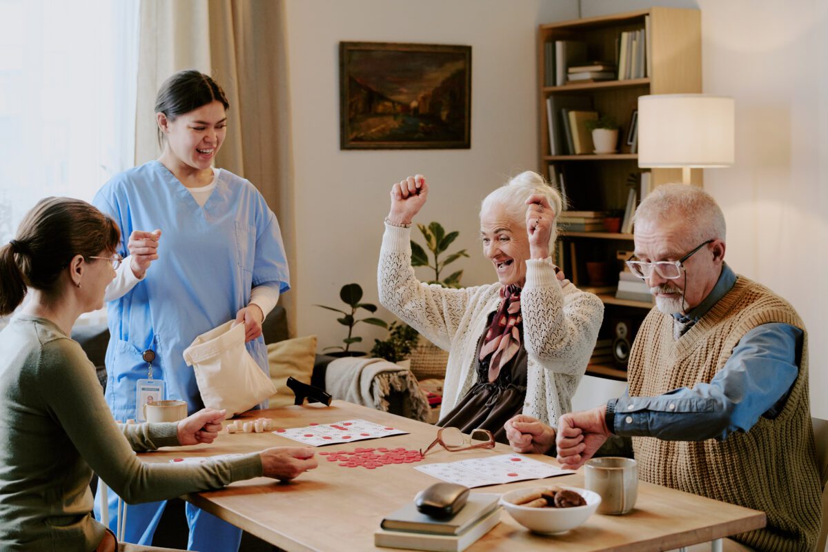 Senior Woman Celebrating Bingo Win with Nurse and Elderly Friends